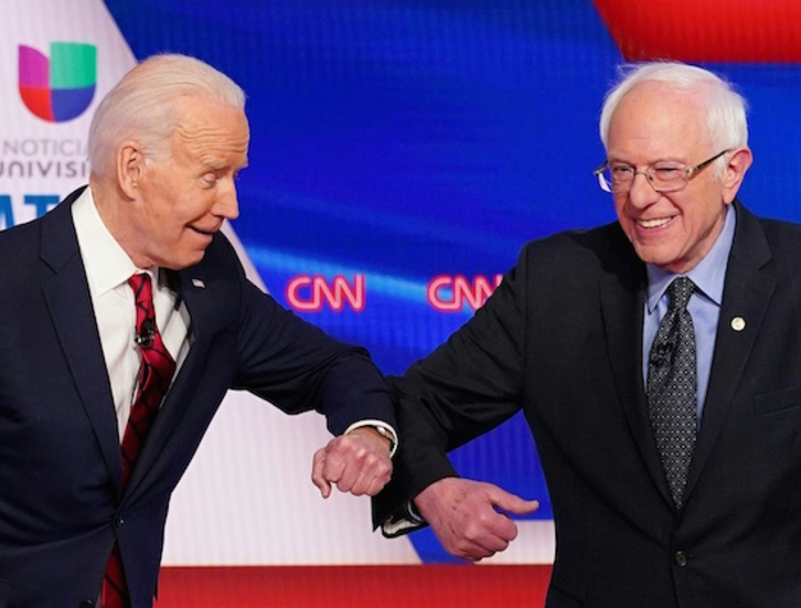 Biden saluda con el codo a Sanders. (Mandel NGAN / AFP)