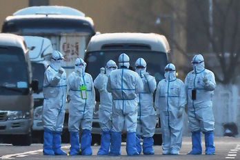 Operarios ataviados con trajes protectores en Pekín. (Greg BAKER/AFP)