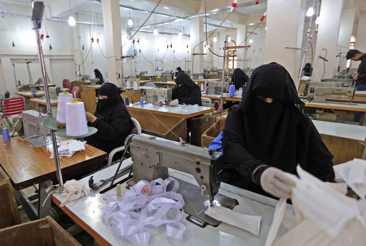 Mujeres yemeníes confeccionan mascarillas en la fábrica más vieja del país. (Mohammed HUWAIS/AFP)