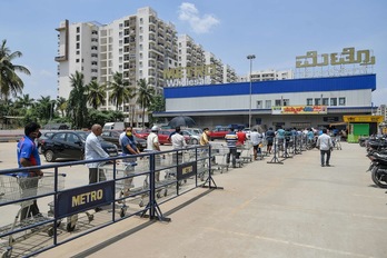 Gente esperando en la cola para entrar en un supermercado de la ciudad india de Bangalore. (Manjunath KIRAN | AFP)