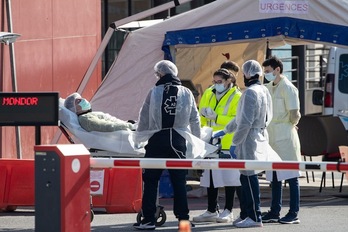 Los profesionales sanitarios atienden a un paciente en la recepción de urgencias improvisada fuera del hospital Henri Mondor, en Creteil. (Thomas SAMSON /AFP)