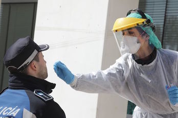 Una enfermera realiza un test a un policía municipal. (Rafa ALBARRACÍN/AFP)