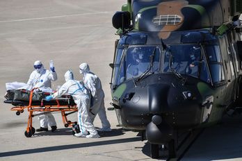 Sanitarios cargan a un paciente infectado en una ambulancia después de desembarcar de un helicóptero en la base aérea de Nimes, al sur de Estadi francés. (Pascal GUYOT/AFP)