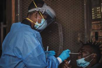 Un funcionario del Departamento de Salud de Gauteng toma muestras de un hombre durante una prueba de detección de coronavirus en Johannesburgo, Sudáfrica. (Marco LONGARI/AFP)