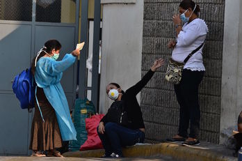 Varias mujeres hondureñas conversan a las puertas de la Escuela Universitaria Hospital de Tegucigalpa. (Orlando SIERRA/AFP)