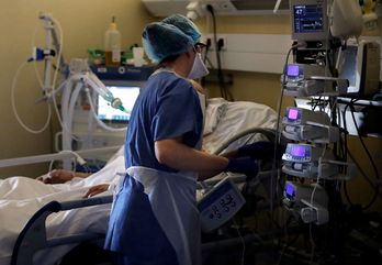  una enfermera atiende a un paciente intubado y sedado infectado con COVID-19 en la unidad de cuidados intensivos del hospital privado Peupliers en París.  (Thomas COEX/AFP)