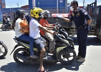 Un policía de Dili, capital de Timor-Leste, pide a los motoclistas que respeten la norma de un solo viajero por vehículo. (Valentino Darriel DE SOUSA | AFP) 