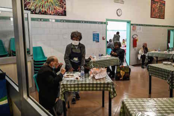 Voluntarios sirven alimentos en un comedor social italiano. (Vincenzo PINTO/AFP)