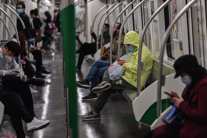 Viajeros en el metro de Wuhan. (Hector RETAMAL / AFP)