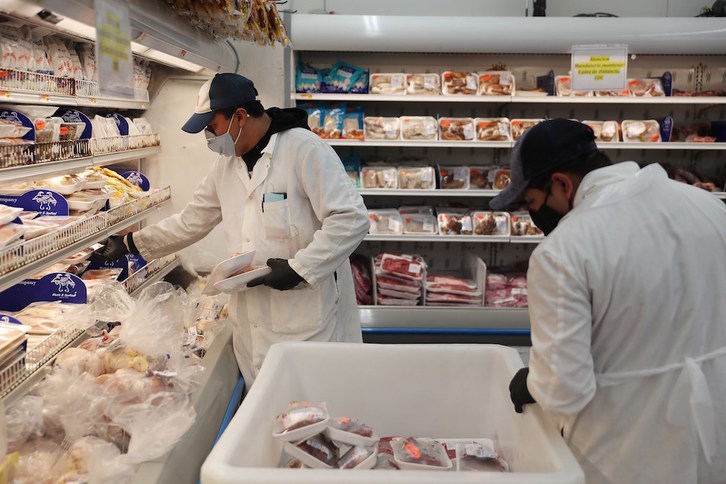 Trabajadores en un supermercado en Miami. (Joe RAEDLE / AFP)