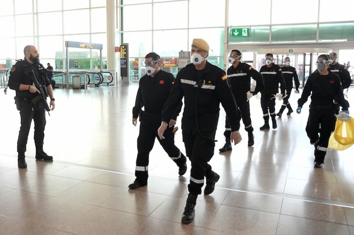 Militares. algunos de ellos armados, en el Aeroport del Prat antes de realizar labores de desinfección. (Josep LAGO/AFP)