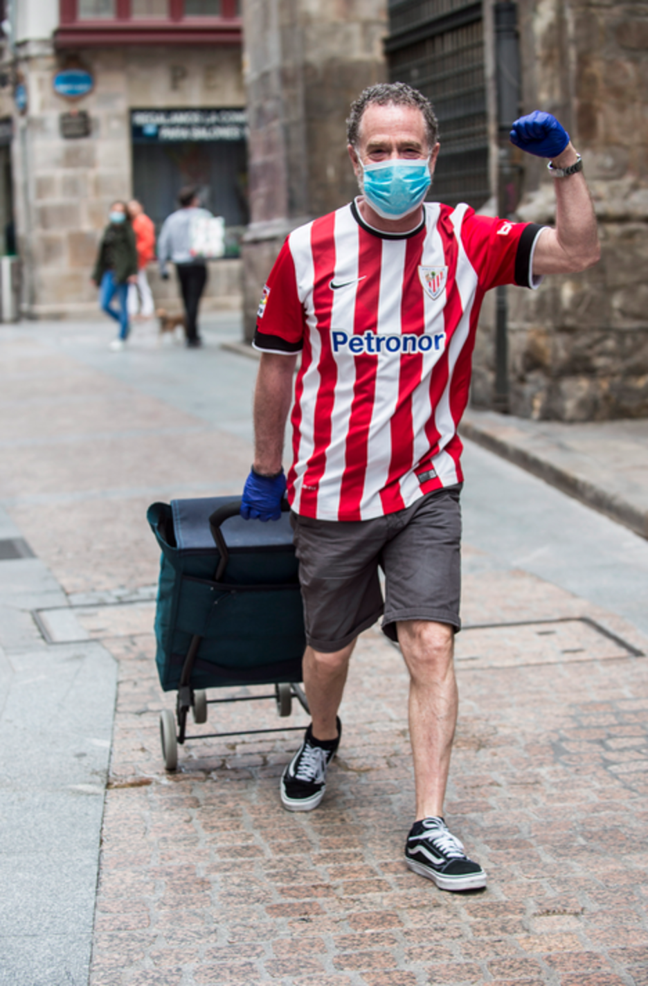 Un hombre con la camiseta del athletic en el Casco viejo de Bilbo. Personas en los balcones con banderas del athletic. (Marisol RAMIREZ/FOKU).