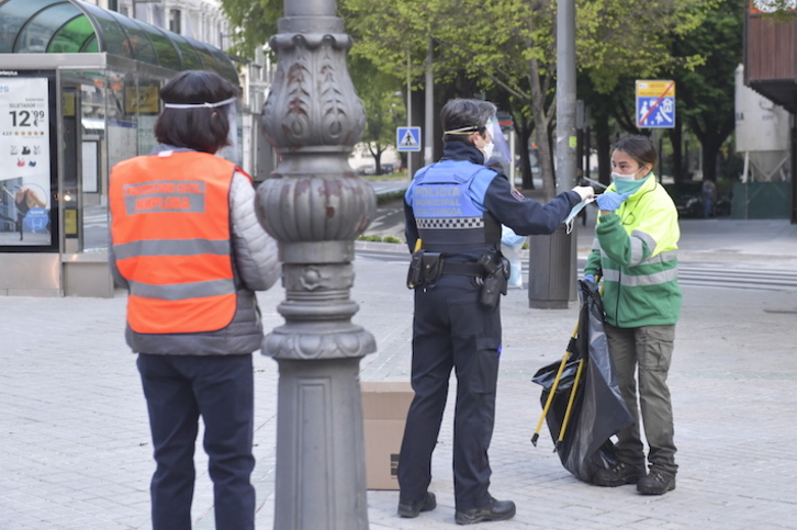 Un policía municipal de Iruñea entrega una mascarilla a una operaria. (Idoia ZABALETA/FOKU)