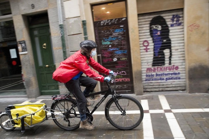 Una repartidora en bicicleta por las calles de Iruñea. (Iñigo URIZ / FOKU)