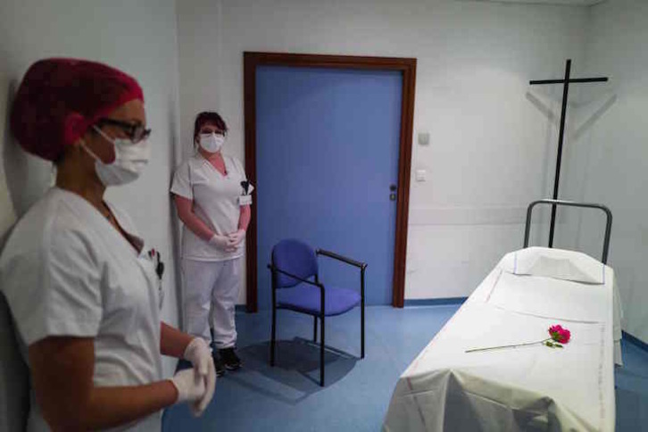 Trabajadoras del servicio mortuorio posan junto a una camilla en la morgue del hospital Emille Muller. (Sebastien BOZON/AFP)