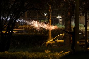 Un manifestante lanza un cohete pirotécnico durante las protesta en Villeneuve la Garenne. (GEOFFROY VAN DER HASSELT  / AFP)