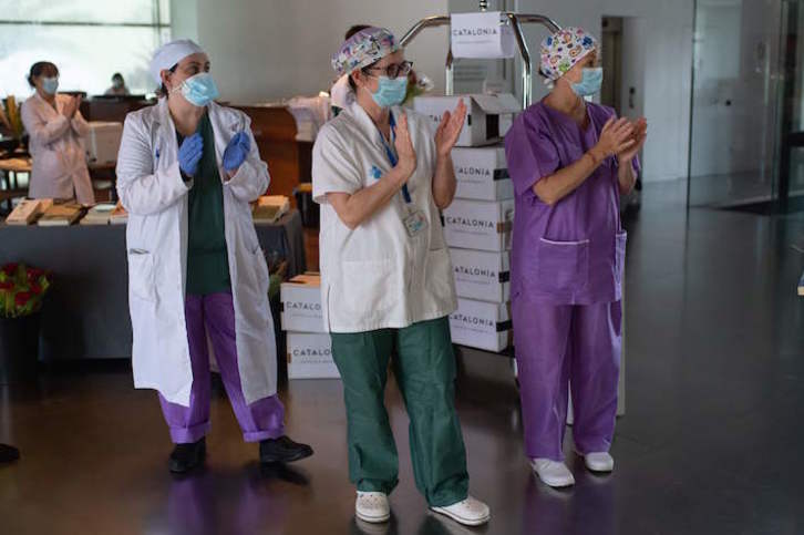 Sanitarios catalanes aplauden a un paciente que ha recibido el alta médica. (Josep LAGO/AFP)