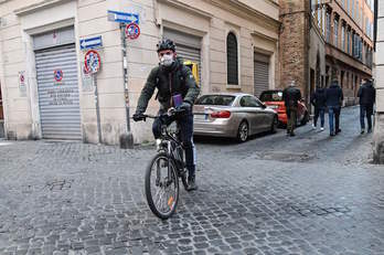 Un ciclista circula con máscara por las calles de Roma. (Andreas SOLARO/AFP)