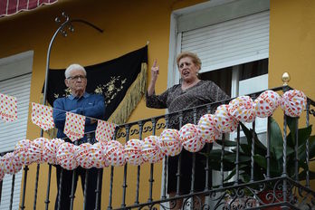 Una pareja mayor celebra la Feria de Abril desde el balcón (Cristina QUICLER/AFP)