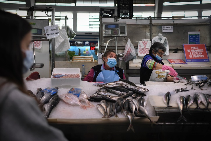 Voluntarios compran pescado en el mercado lisboeta de Benfica para llevarlo a los ancianos que no pueden salir. (Patricia DE MELO MOREIRA/AFP