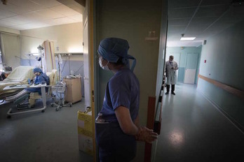 Una enfermera mira a una paciente con Covid-19 en un hospital de París. (Joel SAREB/AFP)