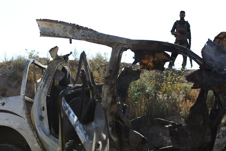 Hashed al-Shaabi milizia xiien kide bat erasoaren hondakinei begira. (Ahmad AL-RUBAYE/AFP) 