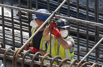 Empleados trabajan a lo largo de la línea de ensamblaje que produce tanto el vehículo eléctrico Renault Zoe. (Martin BUREAU/AFP)