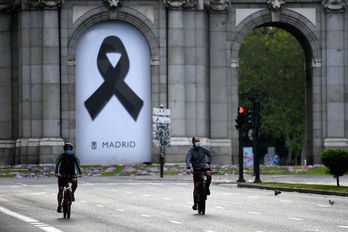 Un lazo negro en la Puerta de Alcalá de Madrid recuerda a los fallecidos por coronavirus. (Gabriel BOUYS/AFP)