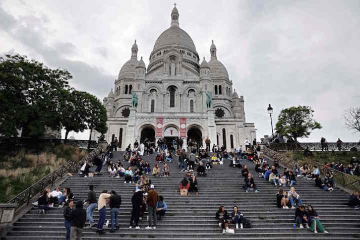 Grupos de personas sentadas en el Sagrado Corazón de París. (Thomas COEX/AFP)