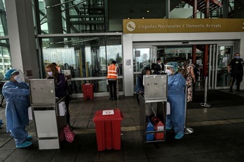 Servicios de limpieza desinfectan una de las entradas del Aeropuerto Internacional de El Dorado en Bogotá. (Juan BARRETO/AFP)