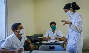 La doctora Liz Caballero, junto con dos alumnos que la acompañan para detectar casos de coronavirus. (Adalberto ROQUE/AFP)