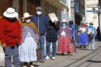 Vecinos de la ciudad andina de Puno, en Perú, aguardan para informarse de cómo retirar fondos de pensiones para hacer frente a la crisis generada por la pandemia. (Carlos MAMANI/AFP)