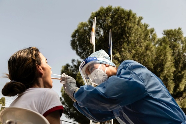 Sanitaria toma una muestra a una trabajadora de una escuela de Nicosia, en Chipre. (Iakovos HATZISTAVROU / AFP)