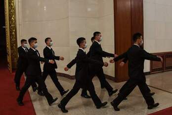 Un grupo de agentes de seguridad vigilando la celebración de la asamblea china anual. (Leo REMIREZ/AFP)