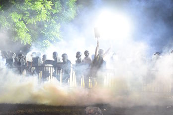 Un manifestante pasa entre el humo y delante de la Policía en las inmediaciones de la Casa Blanca. (ROBERTO SCHMIDT / AFP) 