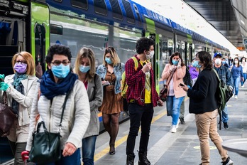 Pasajeros llegan a la estación de Cardona en Milán con medidas de protección frente al coronavirus. (Miguel MEDINA/AFP)