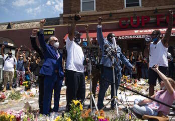 En el centro, Terence Floyd, hermano de George, en el acto familiar en el lugar de la muerte. (AFP)