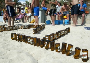 Imagen de archivo de turistas alemanes que hacen figuras con botellines de cerveza en la arena de una playa de Mallorca. (Jaime REINA | AFP) 