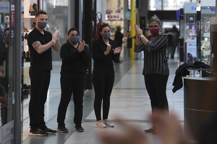 Trabajadores de un centro comercial de Montevideo, la capital de Uruguay, celebran su reapertura el 9 de junio. (Pablo PORCIUNCULA/FP)