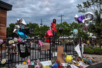 Un hombre, en el lugar donde un policía mató a Brooks, lleno de flores y otras ofrendas y reivindicaciones. (Chandan KHANNA/AFP)