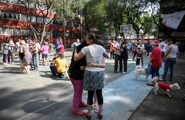 Residentes de Ciudad de México se abrazan tras abandonar sus viviendas al sentir el sismo. (Alfredo ESTRELLA / AFP)