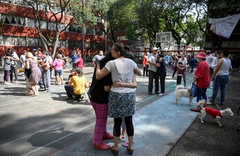 Residentes de Ciudad de México se abrazan en la calle tras salir de sus viviendas al sentir el terremoto. (Alfredo ESTRELLA / AFP)