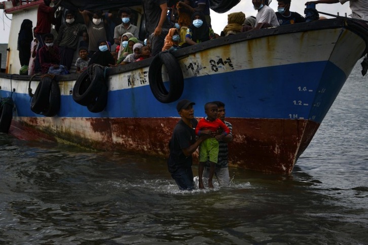 Pescadores de Aceh evacúan a un niño rohinyá de la barcaza a la deriva. (Chaideer MAHYUDDIN / AFP)