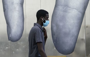 Pertsona bat, babeserako maskara jantzita, New Yorken. (TIMOTHY A. CLARY/AFP)