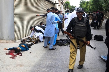 Polizia ikertze lanetan gorpu baten ondoan. (Asif HASSAN-AFP) 