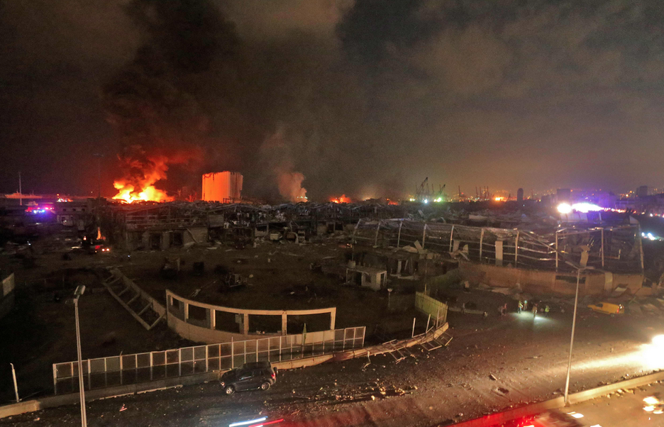 Un incendio continua por la noche en el lugar de la explosión. (STR/AFP).