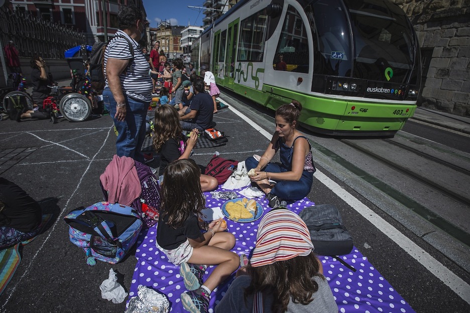 Un tranvia circula junto a la protesta. (Aritz LOIOLA/FOKU)