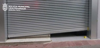 Imagen de la persiana del comercio, forzada para poder cometer el robo. (POLICÍA MUNICIPAL DE IRUÑEA)