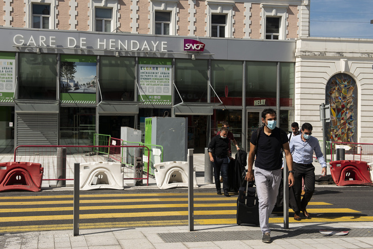 Usuarios de la estación de tren de Hendaia portan máscaras para protegerse del virus. (Guillaume FAUVEAU)