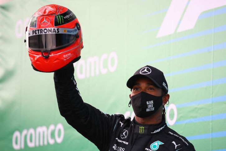 Hamilton saluda al público tras empatar con Schumacher a 91 triunfos. (Bryn LENNON/AFP)